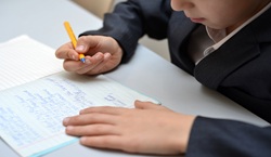 pupil writing in exercise book